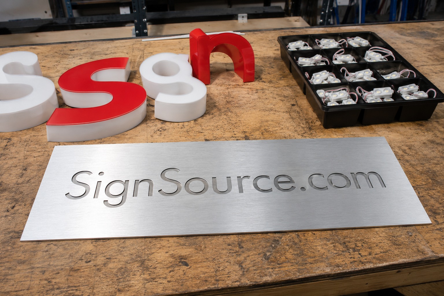 Aluminum SignSource.com blank with channel letter faces and LED modules in a workshop