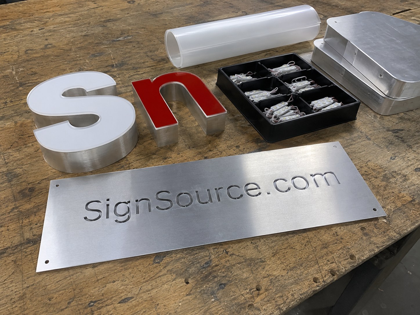 Aluminum SignSource.com blank with channel letter faces and LED modules on a shop bench